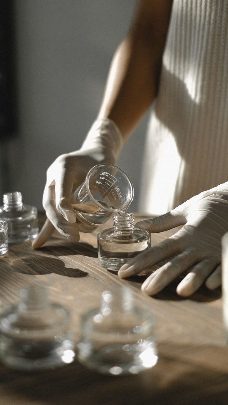 Perfumer pouring fragrance into a glass bottle